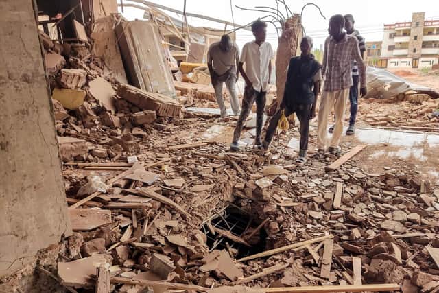 People stand in the rubble as they inspect a house that was hit by an artillery shell in the Azhari district in the south of Khartoum on June 6, 2023. The United States and Saudi Arabia on June 4 made a renewed push for truce talks between Sudan's warring generals as deadly fighting has raged into its eighth week. Multiple ceasefires have been agreed and broken, and Washington slapped sanctions on the two warring generals last week, blaming both sides for the "appalling" bloodshed. (Photo by AFP) (Photo by -/AFP via Getty Images)