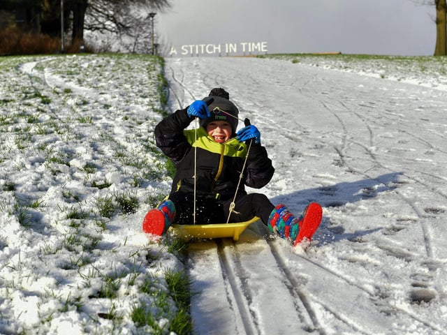 Darragh McCartney (8) enjoys a slide in the snow in Brooke Park on Tuesday morning. Photo: George Sweeney