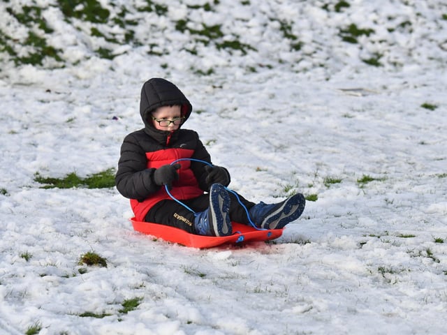 Children enjoy a day off school and a slide in the snow in Brooke Park on Thursday afternoon. Photo: George Sweeney
