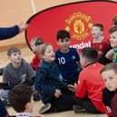 Local primary school pupils prepare to meet Manchester United mascot Fred the Red at St Joseph's Boys School.