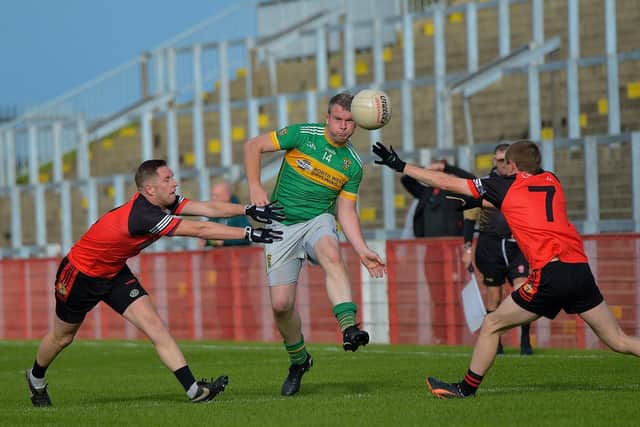 Foreglen’s Kevin O'Connor gets off a pass under pressure from Greenlough's Martin McPeake during the IFC Quarter Final in Celtic Part on Saturday afternoon last. Photo: George Sweeney.  DER2239GS – 089
