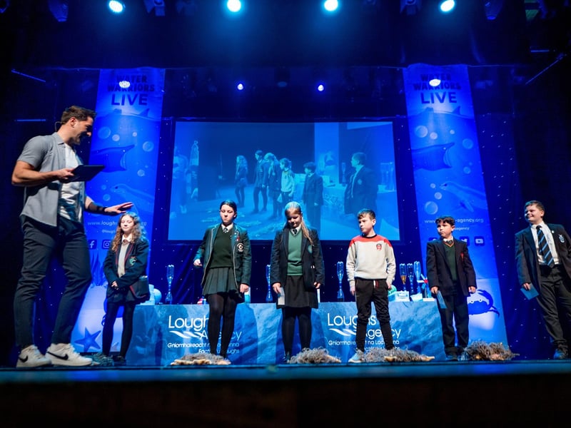 Students from Oakgrove Integrated College, St Cecilia's College, St. Patrick’s College Dungiven, Gaelcholáiste Dhoire, St Joseph's Boys' School and St Columb's College participating onstage in the Water Warriors Starfish Sweep game