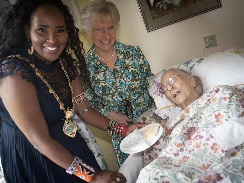 ANNIVERSARY CAKE. . . .The Mayor, Lillian Seenoi-Barr bringing some of the anniversary cake to Longfield Care Home resident 100 years-old Edith Gallagher on Thursday. Centre is Edith's daughter Margaret.
