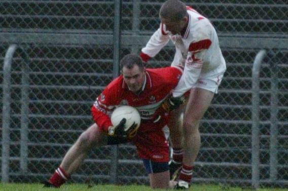 Derry full-back Kevin McCloy is challenged by Tyrone forward Stephen O'Neill in Healy park in January 2004