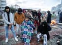 Earthquake survivors sit around a fire in Iskenderun Turkey