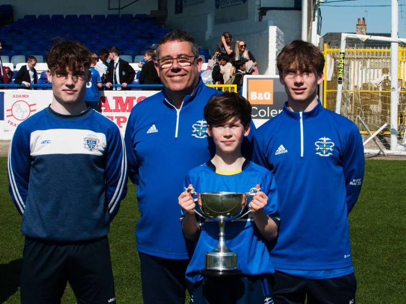 PROUD DAD . . . Coach Xavier Prigent and his three sons, Tom [pictured with cup], Luke who played in last year's U12 final and Yoann.