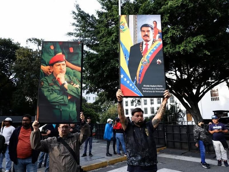 Supporters of Nicolás Maduro hold pictures of the Venezuelan President and his late predecessor Hugo Chávez following the capture of the former by US forces on January 4, 2026.