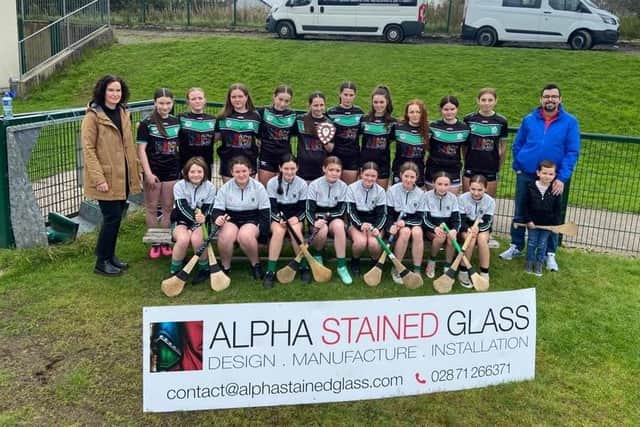 Former camogie player Teresa Coyle, together with Joe Coyle, presents Na Magha’s Under 16 camogie team with a new training kit in recognition of their recent Shield success.