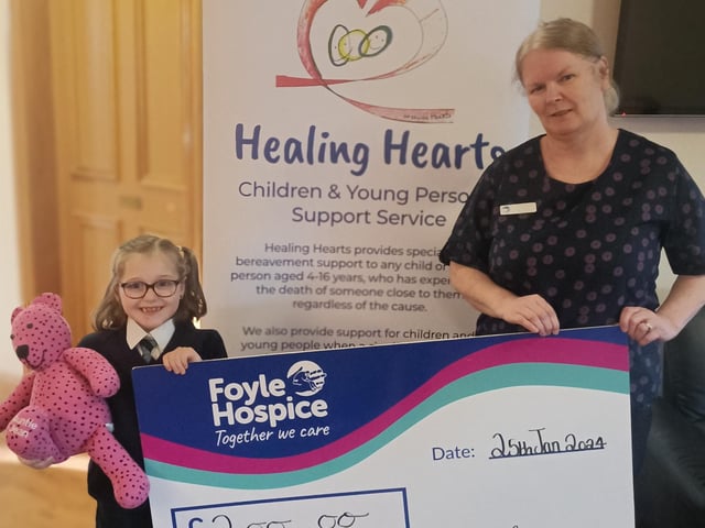 Local youngster, Katie Wilson pictured along with her much loved memory bear, Jean presenting a cheque for £200 to Healing Hearts Facilitator at Foyle Hospice, Michelle Kosky, proceeds from a Santa’s Grotto in the Glenowen Community Association.