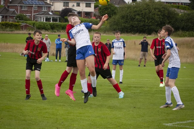 St. John’s midfielder Hannah O’Connor wins this aerial tussle to clear the danger against Hillsborough Boys at Templemore Sports Complex on Monday afternoon. (Photos: Jim McCafferty Photography)