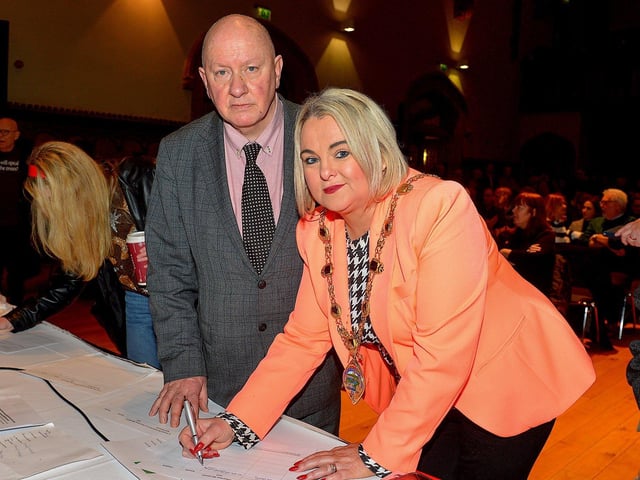 National Union of Journalists assistant general secretary Séamus Dooley loos on as Mayor Sandra Duffy signs a petition to save Radio Foyle at the public meeting, held in the Guildhall on Wednesday evening, opposing planned cuts to jobs and services at the local radio station. George Sweeney. DER2301GS – 13