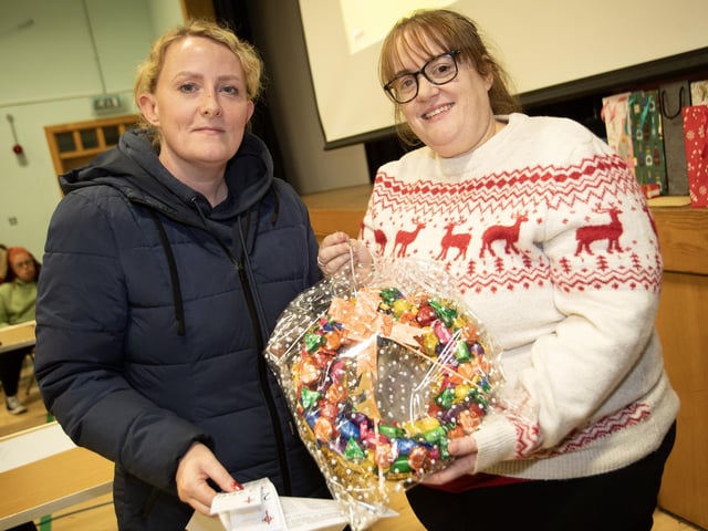Patricia Quigley picks up her prize from Lisa Grant at St. Joseph's Boys School Annual Christmas Rickety Wheel on Thursday night at the school. (Photos: Jim McCafferty Photography)