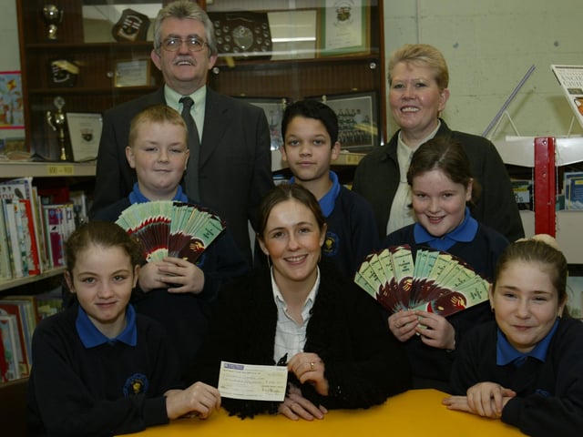 Children in Crossfire representative pictured receiving a cheque for £250 from pupils of St. Teresa's PS who raised the money selling Children in Crossfire badges and bookmarks. In photo are pupils Gemma McCloskey, Owen McGlinchey, SŽan McDaid, Kayleigh Dunne and Annmarie McCloskey with school principal Mr Brady and class teacher Mrs Doneghy. (0402JB11)