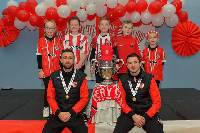 Derry City defenders Daniel Lafferty and Ciaran Coll pictured with St Eithnes Primary School pupils Chloe Scott, Katie Morrison, Liam Doherty, Noah Doran and Olivia Redden during a visit to the school, with the FAI Cup, on Wednesday morning. Photo: George Sweeney.  DER2246GS  079