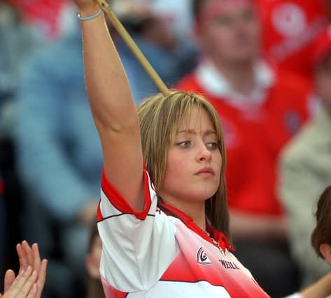 A young fan holds her flag aloft to greet the Derry team. (3108A29)