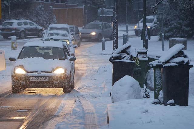 LEATHERHEAD, UNITED KINGDOM - JANUARY 13: Cars queue past un-emptied rubbish bins on January 13, 2010 near Leatherhead, England. Further snow showers have caused the closure of Gatwick Airport and a number of schools in south east England (Photo by Peter Macdiarmid/Getty Images)
