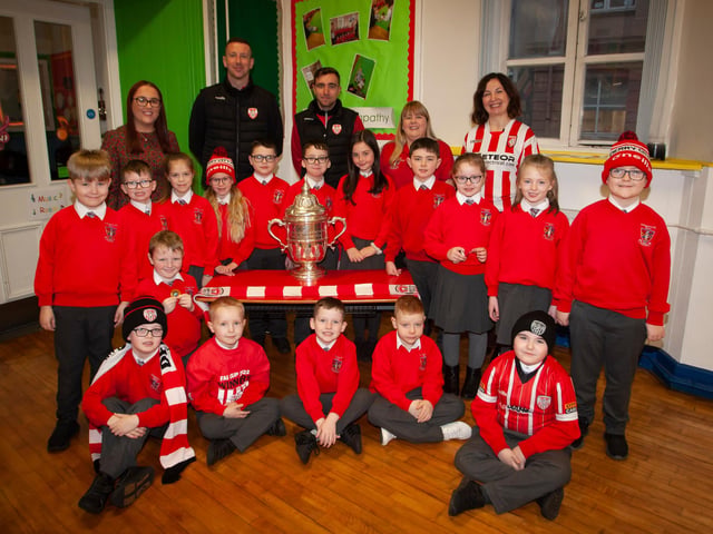 P4 pupils at St. Eugene’s PS show their support for Derry City on Monday last as players Shane McEleney and Joe Thompson brought the FAI Cup to the school.