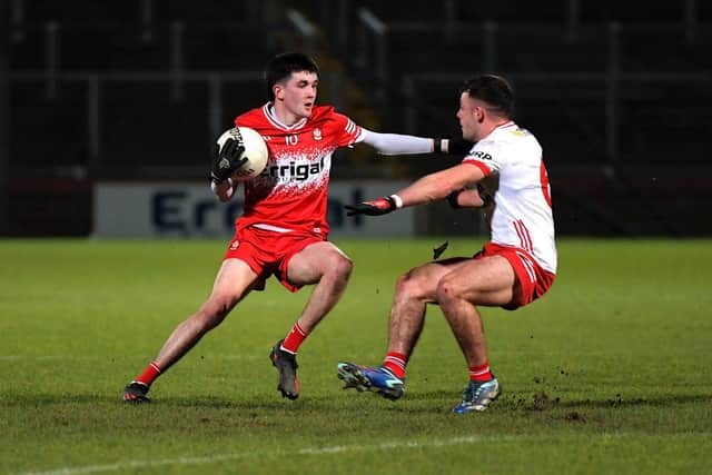 Cahir Spiers of Derry shields the ball from Tyrone’s Michael Rafferty . Photo: George Sweeney