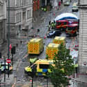 Police officers cover with an inflatable tent, behind a firefighter vehicle, the tents delimiting the scene of an incident in Water Street, on the sidelines of an open-top bus victory parade for Liverpool's Premier League title win. Picture: Peter Ellis/AFP via Getty Images