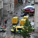 Police officers cover with an inflatable tent, behind a firefighter vehicle, the tents delimiting the scene of an incident in Water Street, on the sidelines of an open-top bus victory parade for Liverpool's Premier League title win. Picture: Peter Ellis/AFP via Getty Images