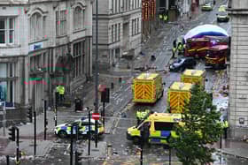 Police officers cover with an inflatable tent, behind a firefighter vehicle, the tents delimiting the scene of an incident in Water Street, on the sidelines of an open-top bus victory parade for Liverpool's Premier League title win. Picture: Peter Ellis/AFP via Getty Images