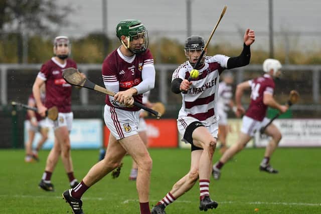 Cathair McGilligan of Banagher gets off a pass as Slaughtneil’s Brendan Rogers closes in. Photo: George Sweeney