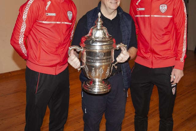 Oakgrove staff member Robert Wright gets a picture with the FAI Cup and Derry players Ciaran Coll and Jamie McGonigle.