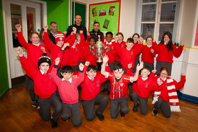 P7 pupils at St. Eugene’s PS show their support for Derry City on Monday last as players Shane McEleney and Joe Thompson brought the FAI Cup to the school.