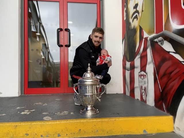 Derry City striker Jamie McGonigle holds Jamie Mark McGrath alongside the FAI Cup trophy.