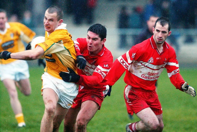 Ryan Lynch makes a tackle as Padraig Kelly looks on at Glen in January 2004.