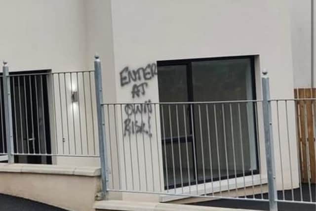 An apparent threat - 'Enter at own risk!' - was sprayed on the exterior wall of one of the houses.