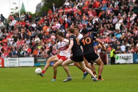 Derry’s Donncha Gilmore off loads the ball under pressure. Photo: George Sweeney