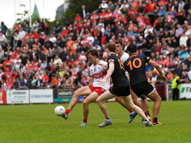 Derry’s Donncha Gilmore off loads the ball under pressure. Photo: George Sweeney