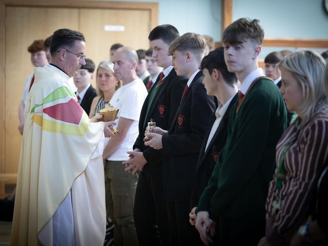 Fr. Shaun Doherty receiving the Consecrated Bread and Wine. : .