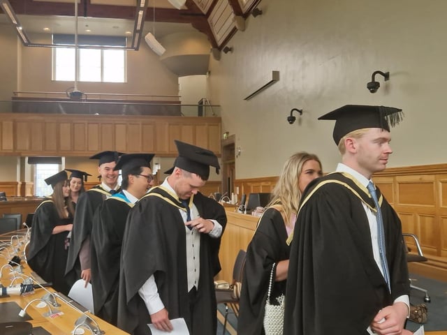Graduates make their way from the Council chamber to the Main Hall in the Guildhall to complete their graduation.