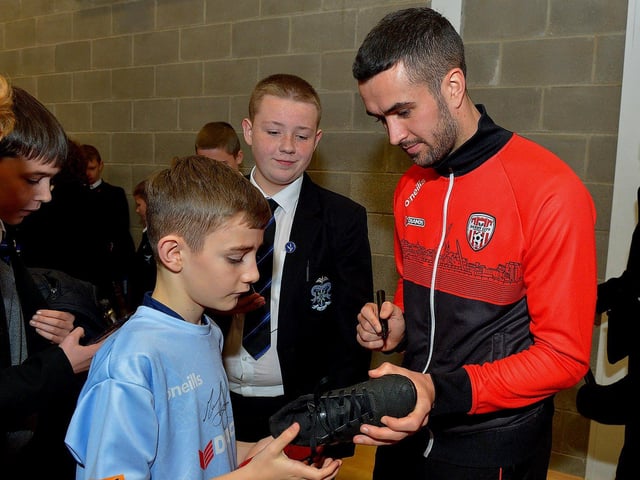 Derry City's Michael Duffy signs autographs for pupils during a visit to the school with the FAI Cup, on Monday . Photo: George Sweeney. DER2247GS 27