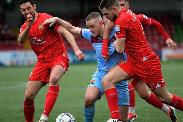 Portadown pair Gary Thompson and Lee Chapmen grapple with Institute’s Mikhail Kennedy. Photo: George Sweeney