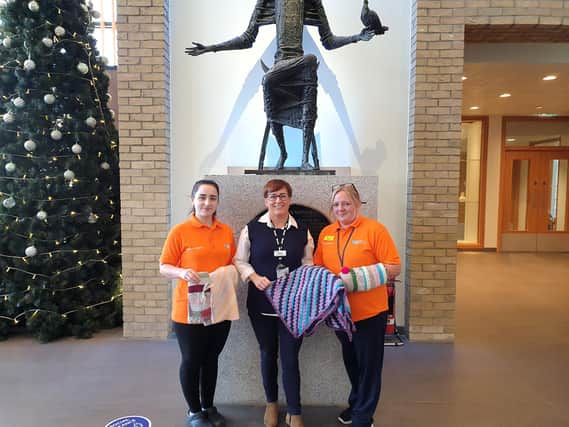 Altnagelvin Hospital Dementia Companions Madeline Pena Hernandez and Sharon McKittrick accepting donations gifted to the hospital for patients with a diagnosis of Dementia. Handing over the donations is Wendy Doherty, Volunteer and Work Experience Coordinator (centre).