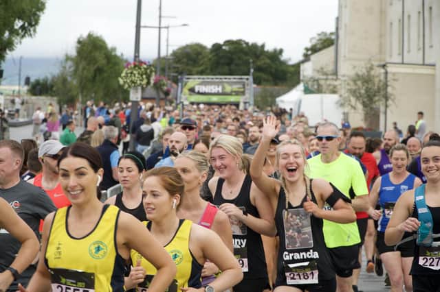 A smile and a wave for the camera as runners begin the 40th edition of the Waterside Half Marathon.