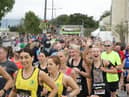 A smile and a wave for the camera as runners begin the 40th edition of the Waterside Half Marathon.