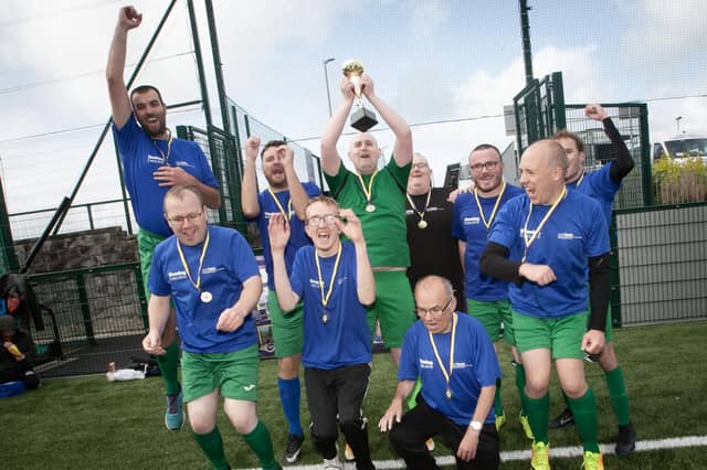 BACK-TO-BACK CHAMPIONS!. . . ..The triumphant Destined FC players celebrate winning Friday's FDST Peace Games tournament at the Shared Village Centre, Waterside.
