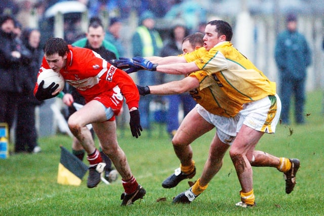 Derry's Enda Muldoon gets away from two Antrim players during the McKenna Cup tie at Glen in January 2004.
