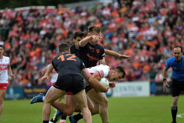 Derry’s Shane McGuigan is bundled to the ground by Armagh players. Photo: George Sweeney