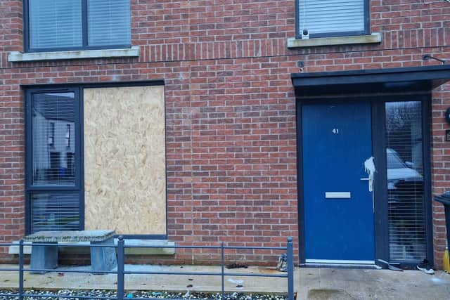 The family's home front window boarded up.