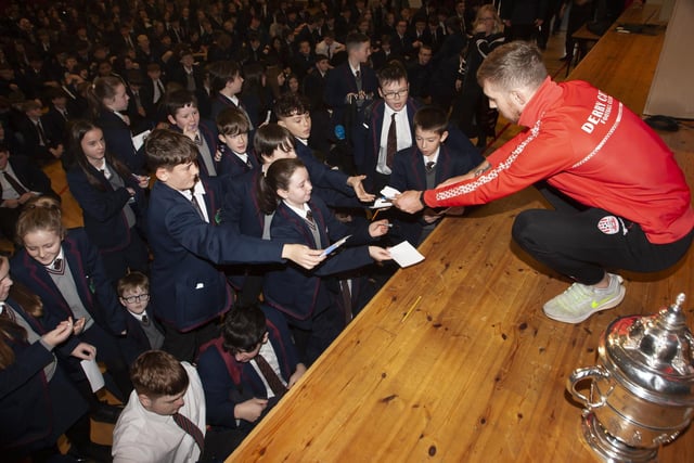 Derry City’s Jamie McGonigle signing autographs for students at Oakgrove Integrated College.