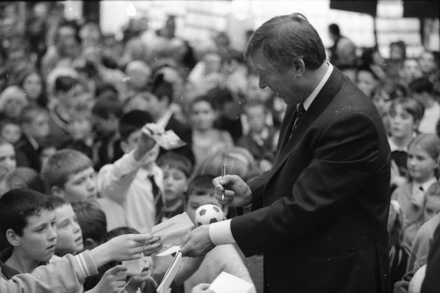 Manchester United manager Alex Ferguson signs autographs during a visit to Foyleside Shopping Centre.