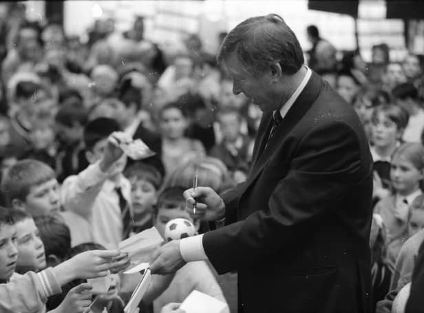 Manchester United manager Alex Ferguson signs autographs during a visit to Foyleside Shopping Centre.