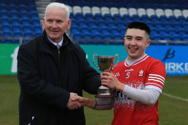 Derry captain Andy McBride receives the Ulster U20 Hurling Cup from Ulster GAA Vice-Chairperson Michael Geoghegan in Corrigan park on Saturday. (Photo: Derry GAA)