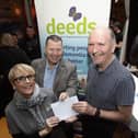 DEEDS CHEQUE. . . . .Sinead Devine, Co-Ordinator, DEEDS, Old Library Trust, accepting a cheque for £5,610 from Willie Barrett, proceeds of monies collected during the Gweedore Reunion 2024 event. In centre is Peter Cunnah from D:Ream. (Photo: Jim McCafferty Photography)