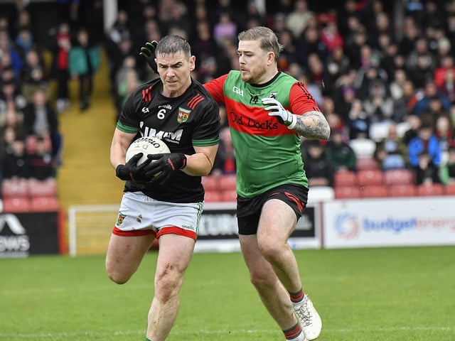 Doire Trasna’s Eoghan Quigg bears down on Cahir Cooke of Slaughtmanus. Photo: George Sweeney
